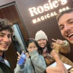 A cheerful selfie of three happy tourists and a smiling staff member inside Rosie's Magical Spa in Vietnam.