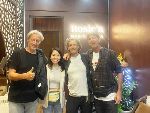 A cheerful photo of three male tourists with a staff member at Rosie's Magical Spa in Vietnam.