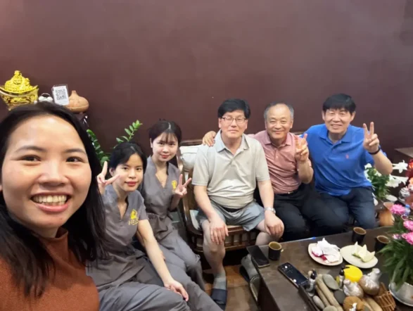 A cheerful group photo of satisfied customers and friendly staff at Rosie's Magical Spa in Vietnam.