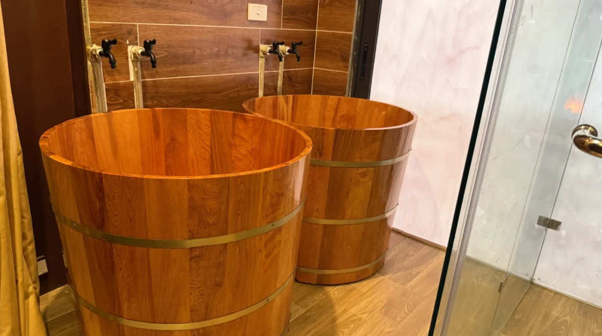 Wooden Bath Tubs at Rosie's Magical Spa - Rosie's Magical Spa Two traditional wooden tubs with brass bands, likely for herbal baths or foot soaks, at Rosie's Magical Spa.