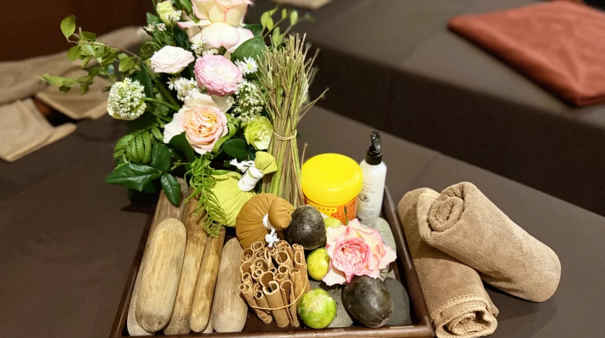 A tray of massage and spa treatment products at Rosie's Magical Spa, including oils, herbs, and hot stones.