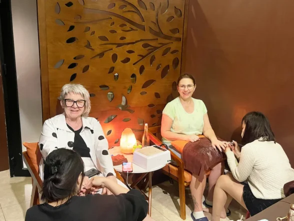 Two clients receiving manicures at Rosie's Magical Spa while relaxing in comfortable chairs.