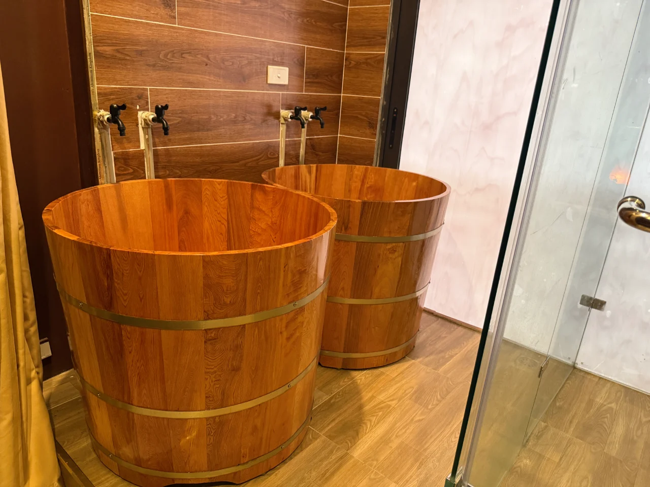 Two traditional wooden foot soaking tubs filled with warm herbal water at Rosie's Magical Spa.